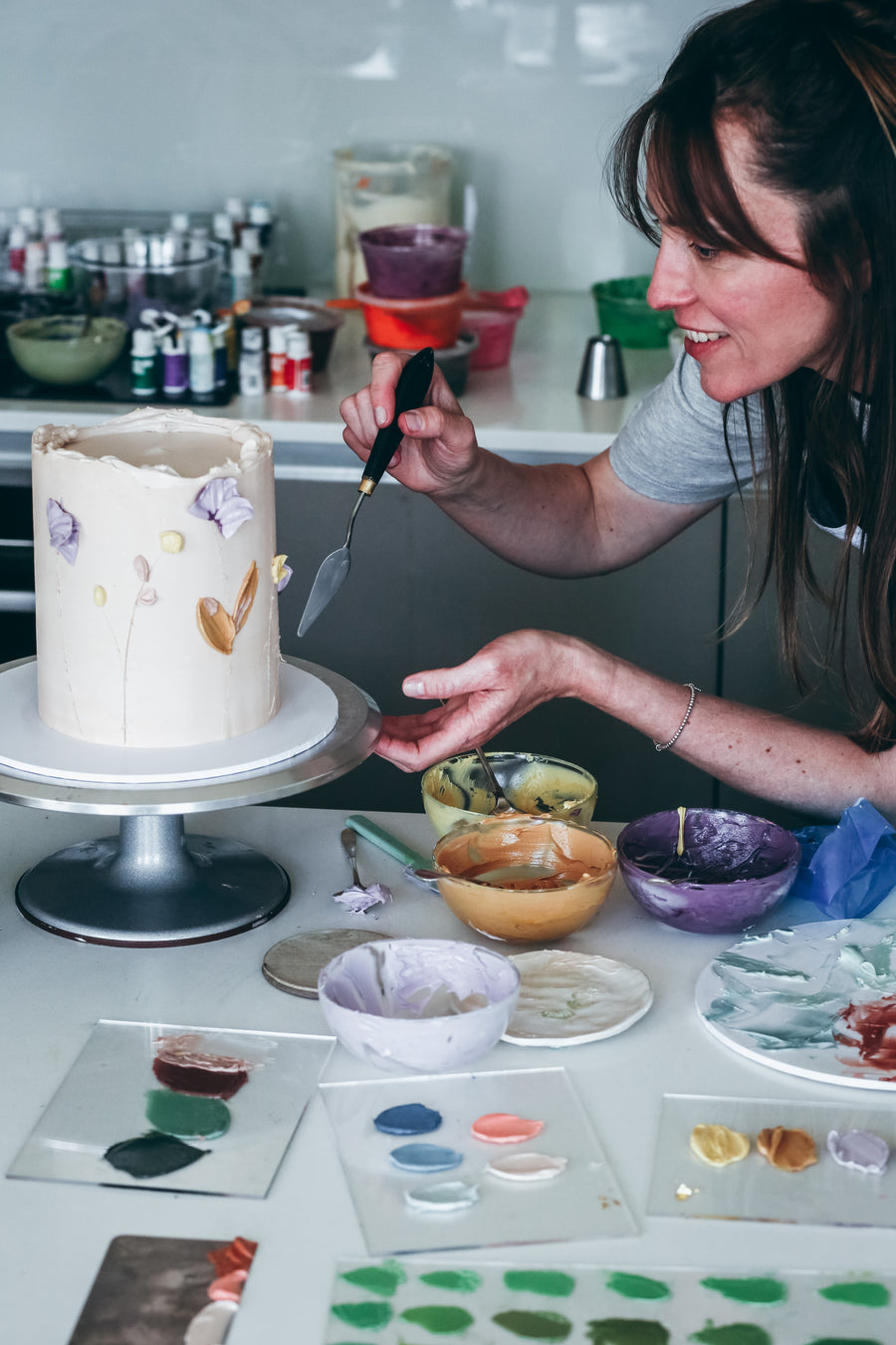 Carol decorating a cake with a unique colour palette made with Colour Mill.